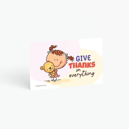 A curved corner wallet card size sticker for children standing in landscape on a white background with text "Give thanks in everything"