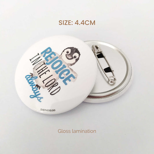 Circular button badge with text rejoice in the Lord and a penguin illustration on a white background, with size and gloss lamination displayed.