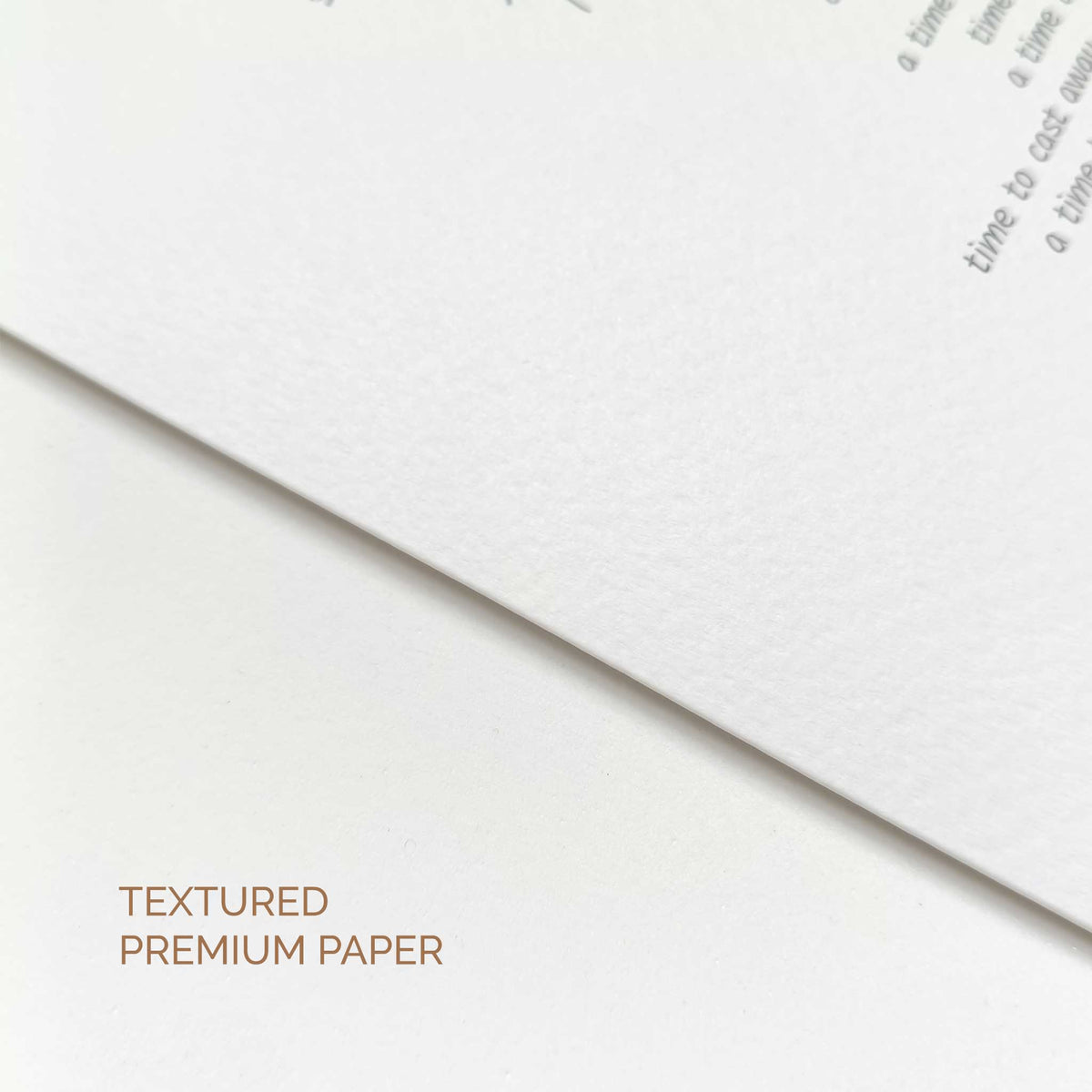 A close-up of textured premium paper in white, with a folded corner showing the surface texture and printed text. Text in the lower left reads 'TEXTURED PREMIUM PAPER'.