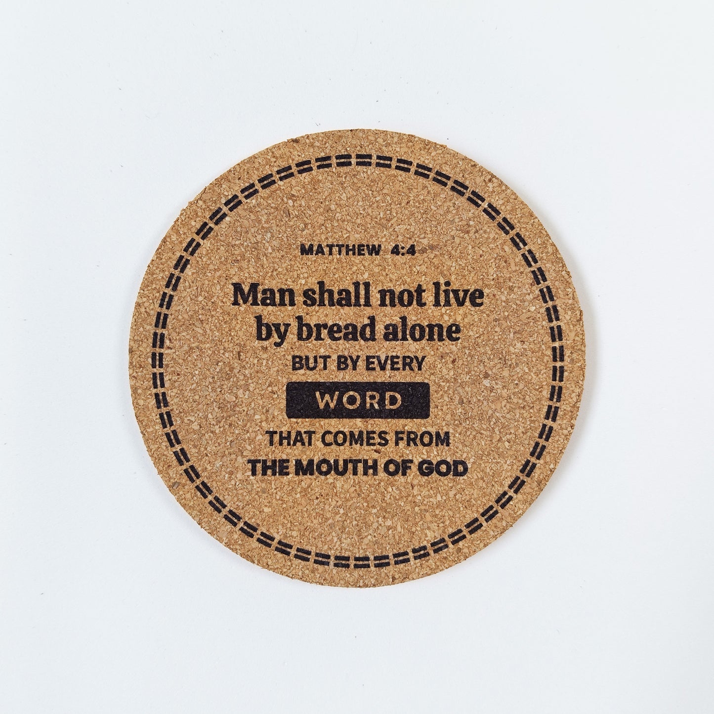 Circle cork coaster with Bible verse Matthew 4:4 Man shall not live by bread alone on a white background
