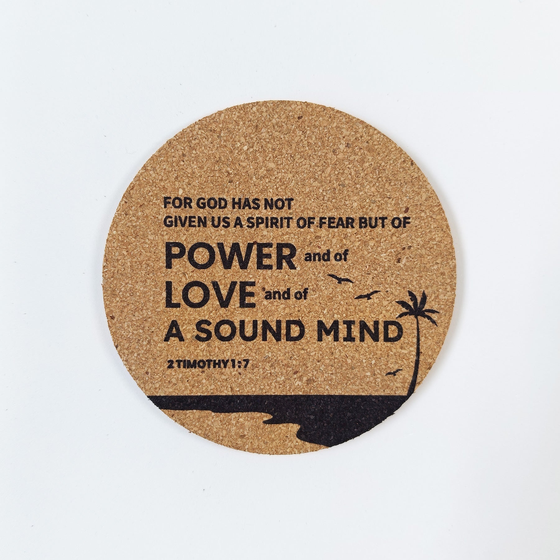 Circle cork coaster with Bible verse 2 Timothy 1:7 and beach silhouette design on a white background
