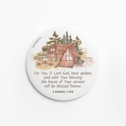flat round button magnet with bible verse the house of your servant on white background with wooden house and trees elements