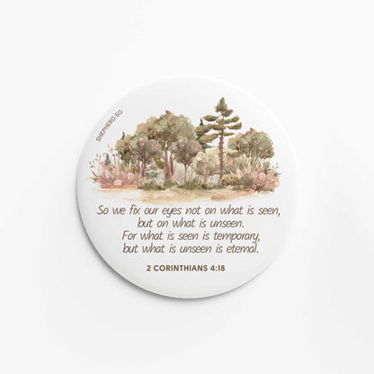 flat round button magnet with bible verse so we fix our eyes not on what is seen on white background with watercolor trees