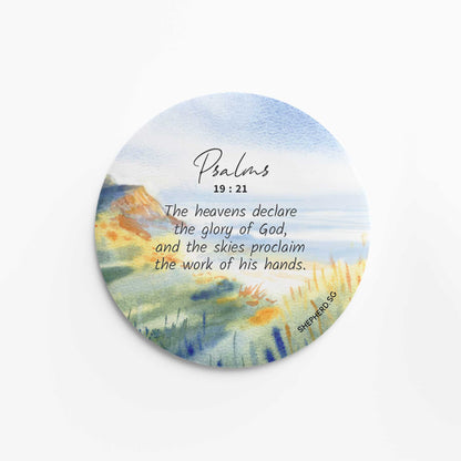 flat round button magnet with bible verse the heavens declare the glory og God on landscape nature background