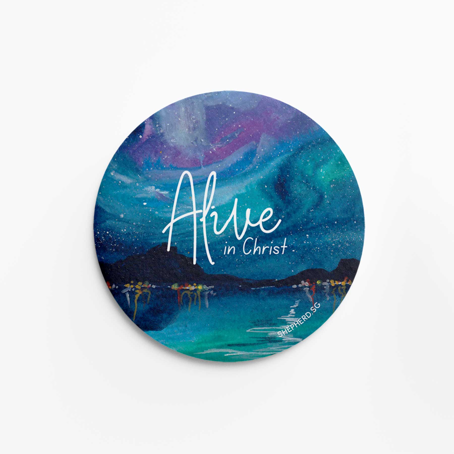 Round pin badge with 'Alive in Christ' text and Northern Lights design on a white background