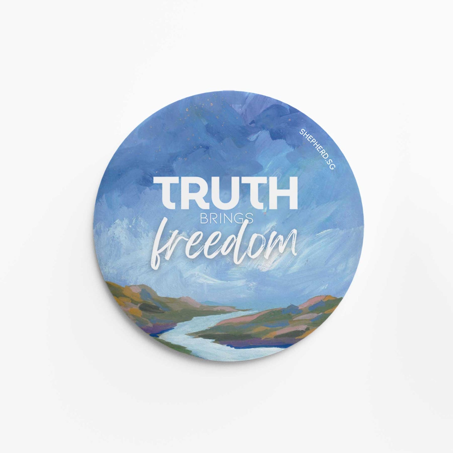 Round pin badge with 'Truth Brings Freedom' text over a scenic watercolor sky landscape on a white background