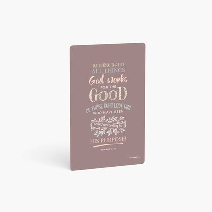 A curved corner wallet card size sticker standing vertically on a white background with Bible verse Romans 8:24 We know that in all things God works for the good