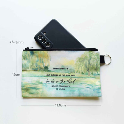 canvas pouch with nature design and Bible verse text, placed on a white surface with smartphone for scale.