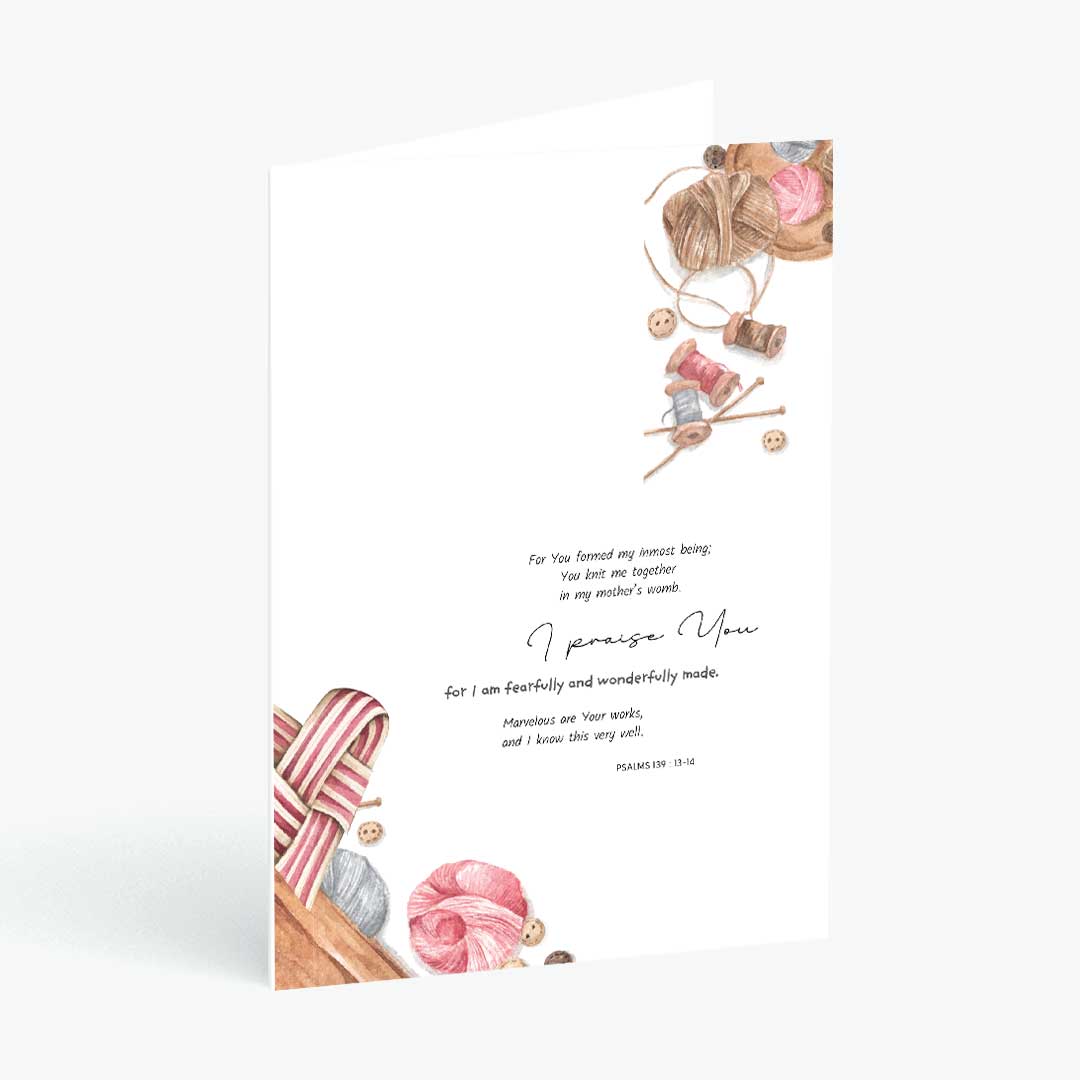 A vertical greeting card with a white background, featuring a watercolor illustration of sewing and knitting supplies in pink, beige, and brown tones. The card includes a Bible verse from Psalm 139:13 and the word 'I praise you' in elegant script.