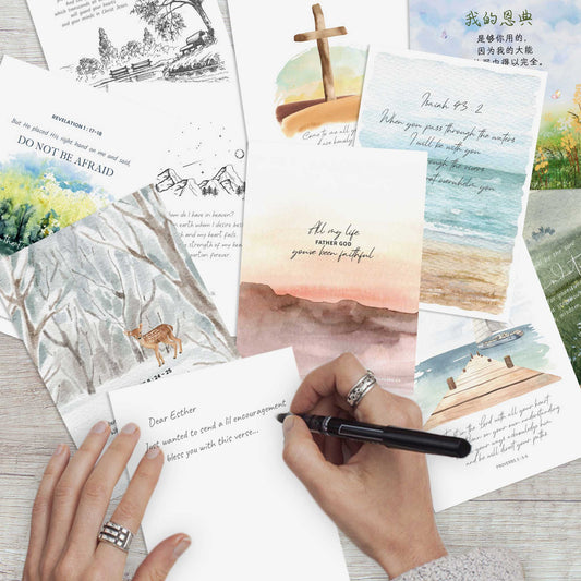 assorted christian cards with watercolor illustrations and bible verses on a wooden table top
