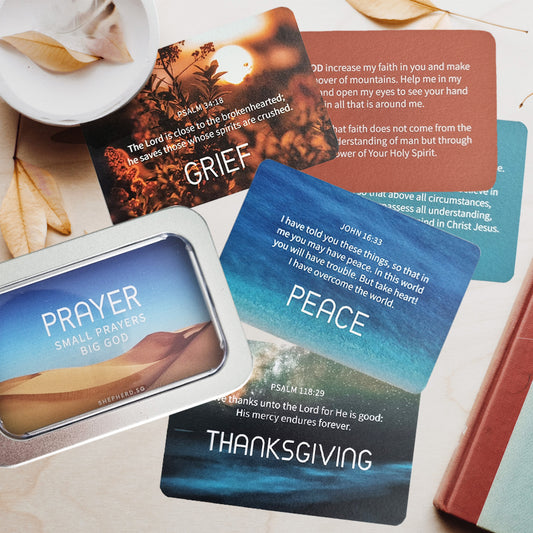 Christian prayer cards designed by shepherd.sg and tin box packaging flat lay on a table with leaves